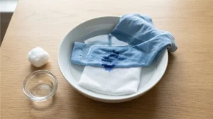 Soaking a ballpoint pen ink stain in rubbing alcohol as a moderate method to remove ball pen stains from clothes.